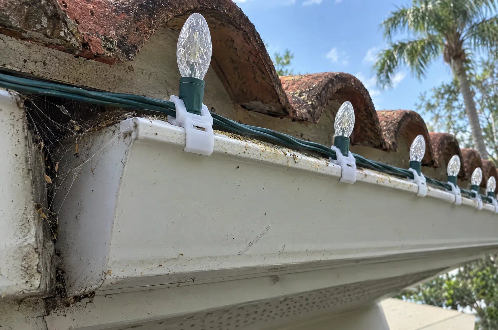 C9 bulbs on clips along a tile-roof gutter
